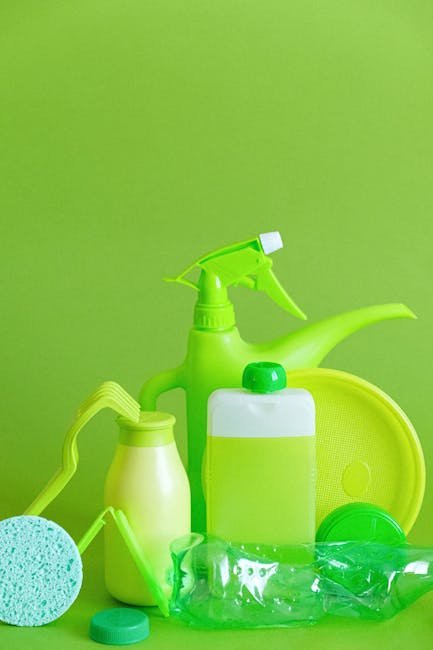 Assorted green cleaning supplies against vibrant green backdrop, promoting eco-friendly sanitation.